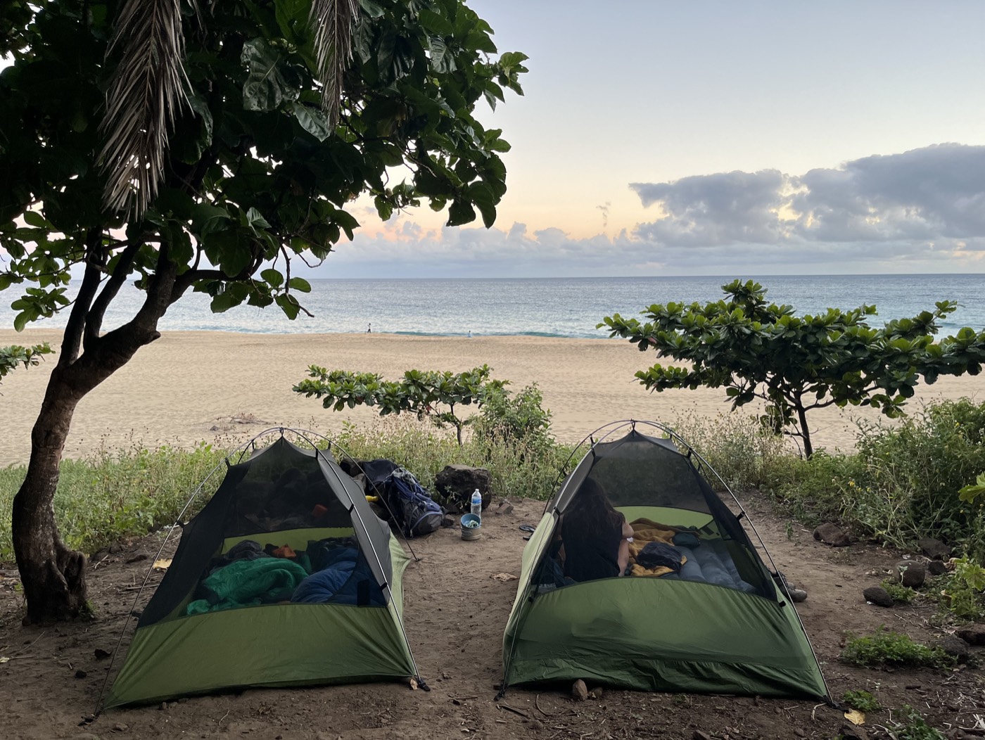 Two tents pitched by the beach at sunset in Hawaii